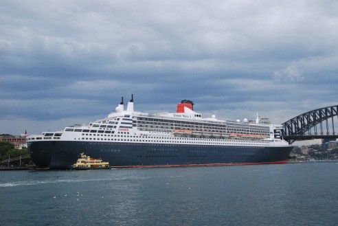 A Sydney ferry is dwarfed by the Queen Mary 2 at Circular Quay.